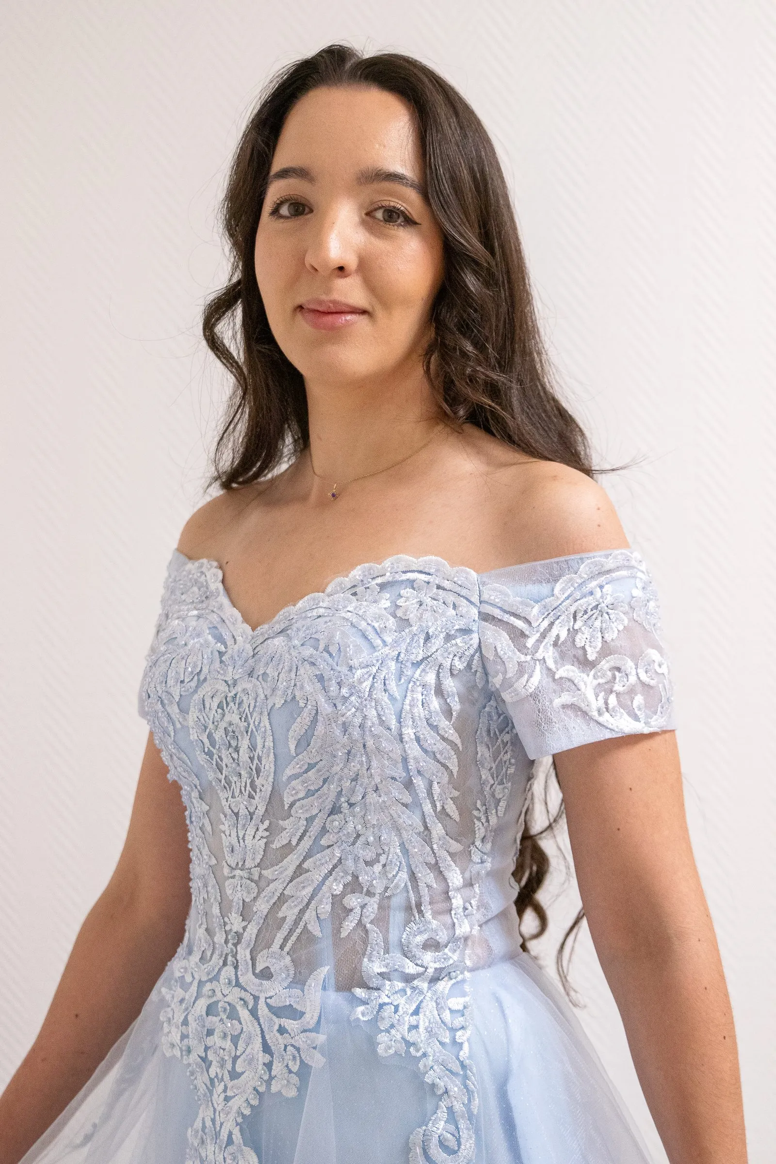 Robe de cérémonie bleu ciel pailletée, portrait buste en intérieur