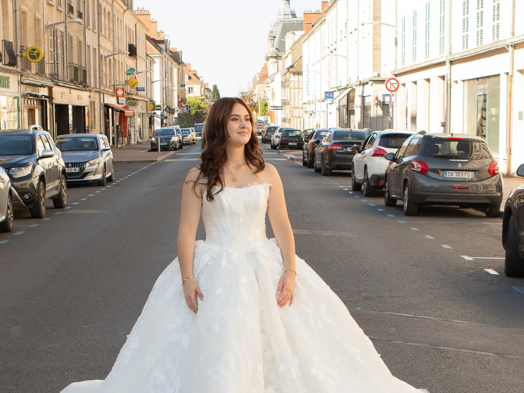 Mariée en robe princesse à bustier brodé, posant au milieu de la rue Aristide Briand à Vitry-le-François