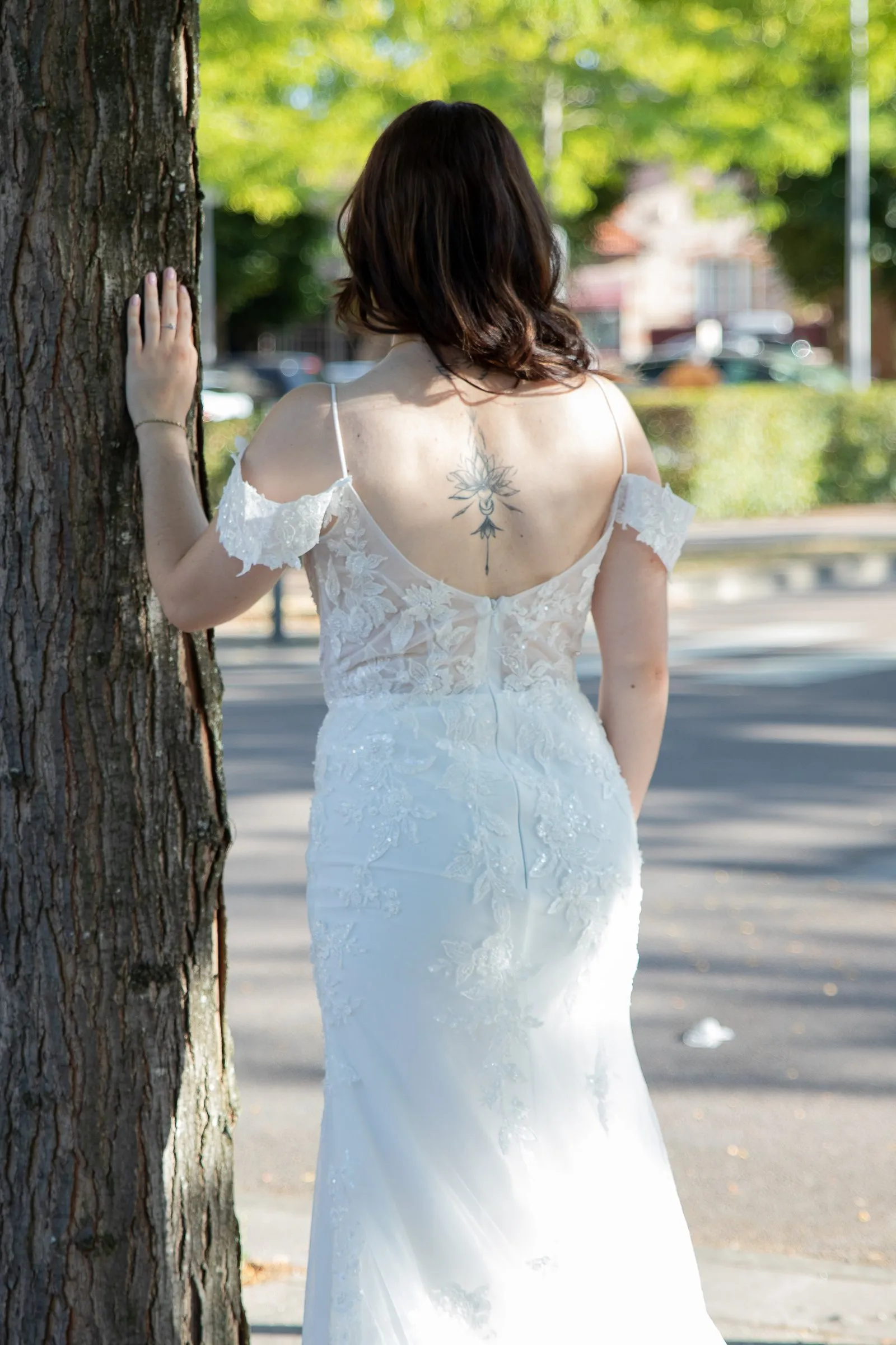 Robe de mariée sirène en dentelle, vue de dos, essayage en extérieur